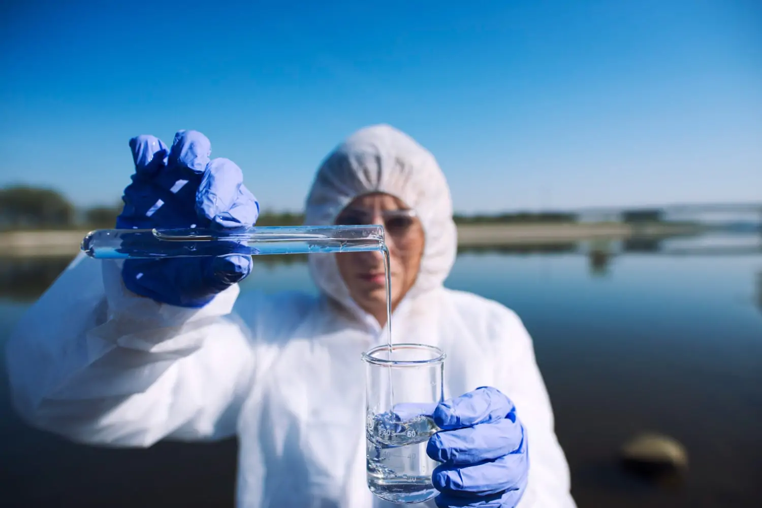 ecologist sampling water from river with test tube 1 min